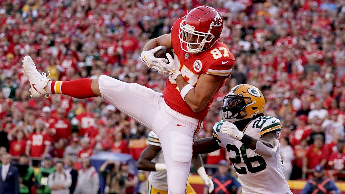 Kansas City Chiefs tight end Travis Kelce (87) catches a touchdown pass as Green Bay Packers safety Darnell Savage (26) defends during the first half of an NFL football game Sunday, Nov. 7, 2021, in Kansas City, Mo.