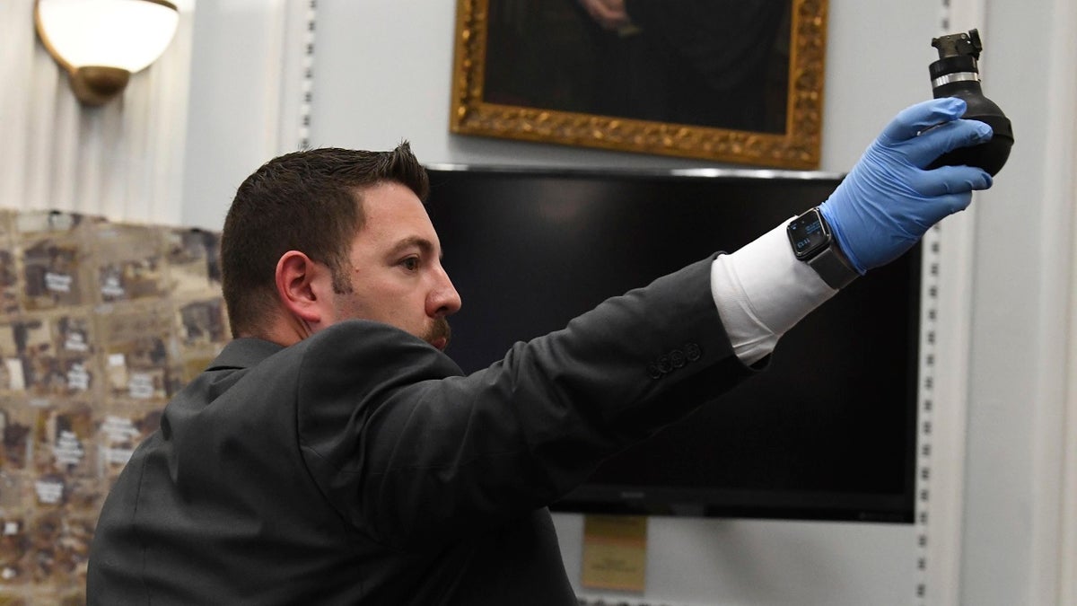 Kenosha Police officer Ben Antaramian shows the jury a tear gas canister that Gaige Grosskreutz testified he picked up out of the street before he was shot by Kyle Rittenhouse during the Kyle Rittenhouse trial at the Kenosha County Courthouse in Kenosha on Monday, Nov. 8, 2021.