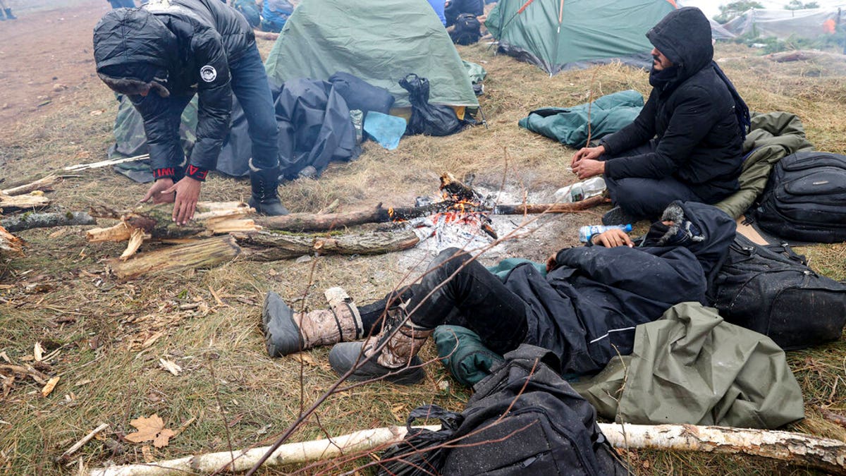 Migrants from the Middle East and elsewhere warmup at the fire gathering at the Belarus-Poland border near Grodno, Belarus, Wednesday, Nov. 10, 2021. ?(Ramil Nasibulin/BelTA pool photo via AP)