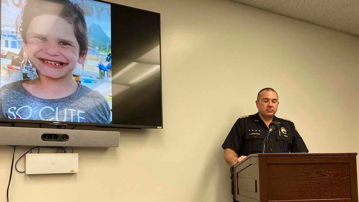 Honolulu Police Maj. Ben Moszkowicz addresses a news conference in Honolulu Wednesday, Nov. 10, 2021, where officers said they had arrested the adoptive parents of Isabella "Ariel" Kalua, shown on the screen to the left. The parents, Lehua and Isaac "Sonny" Kalua, have been charged with second-degree murder in the girl's death. Police say the girl was killed a month before they reported her missing Sept. 13, 2021. 