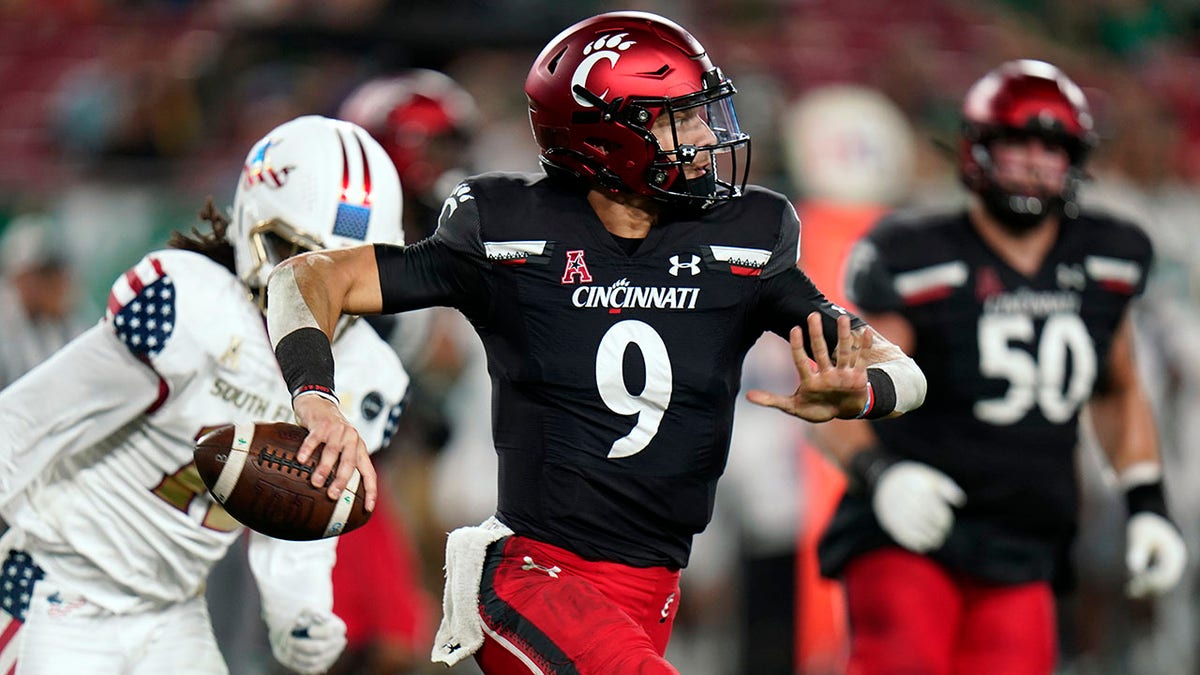 Cincinnati quarterback Desmond Ridder (9) looks to pass as he rolls out against South Florida during the first half of an NCAA college football game Friday, Nov. 12, 2021, in Tampa, Florida.