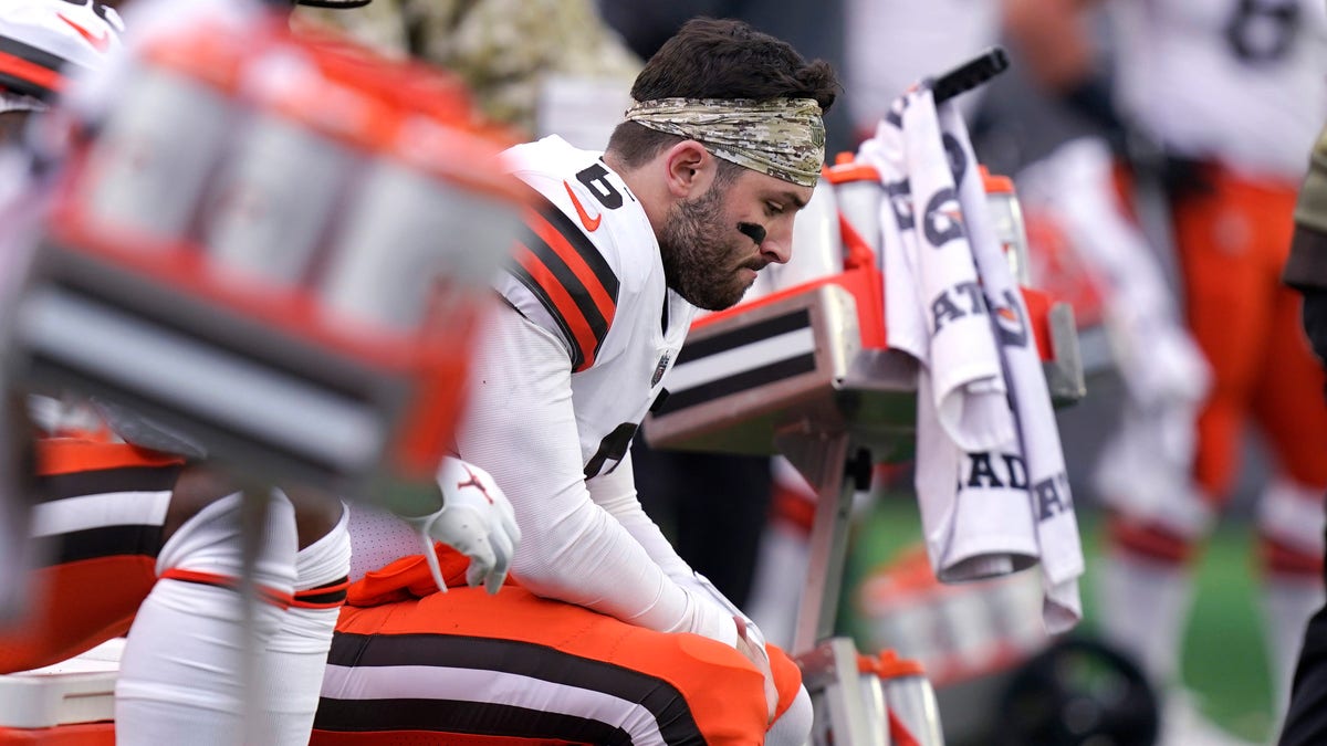 Cleveland Browns quarterback Baker Mayfield sits on the bench after an apparent injury during the second half against the New England Patriots, Sunday, Nov. 14, 2021, in Foxborough, Mass. The Patriots defeated the Browns 45-7. (AP Photo/Steven Senne)