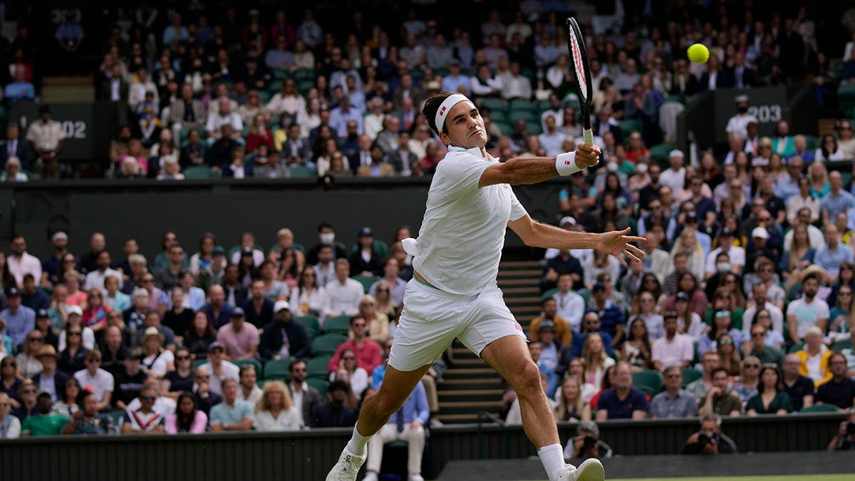 Switzerland's Roger Federer plays a return to Poland's Hubert Hurkacz during the men's singles quarterfinals match on day nine of the Wimbledon Tennis Championships in London, Wednesday, July 7, 2021.