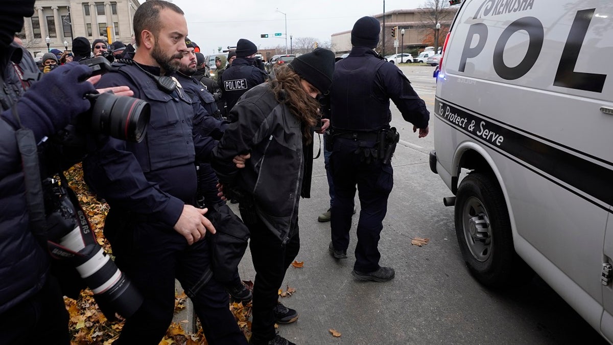 Kenosha police take a person into custody outside the Kenosha County Courthouse, Thursday, Nov. 18, 2021 in Kenosha, Wis., during the Kyle Rittenhouse murder trial. (AP Photo/Paul Sancya)