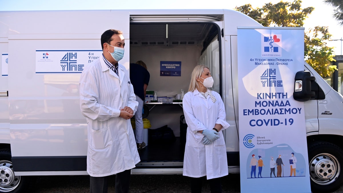 FILE - Medical staff stand outside a mobile COVID-19 vaccination team set up by Health Ministry in the northern city of Thessaloniki, Greece on Tuesday, Oct. 26. 2021. (AP Photo/Giannis Papanikos, File)