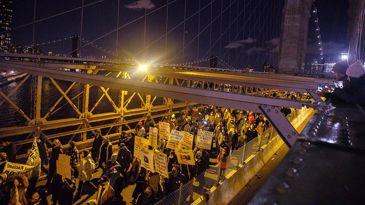 Demonstrators marched across the Brooklyn Bridge on Friday in protest of Kyle Rittenhouse's acquittal. 