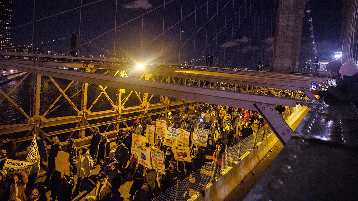 Demonstrators march across the Brooklyn Bridge Friday, Nov. 19, 2021, in New York, following the acquittal of Kyle Rittenhouse in Kenosha, Wis. (AP Photo/Jeenah Moon)