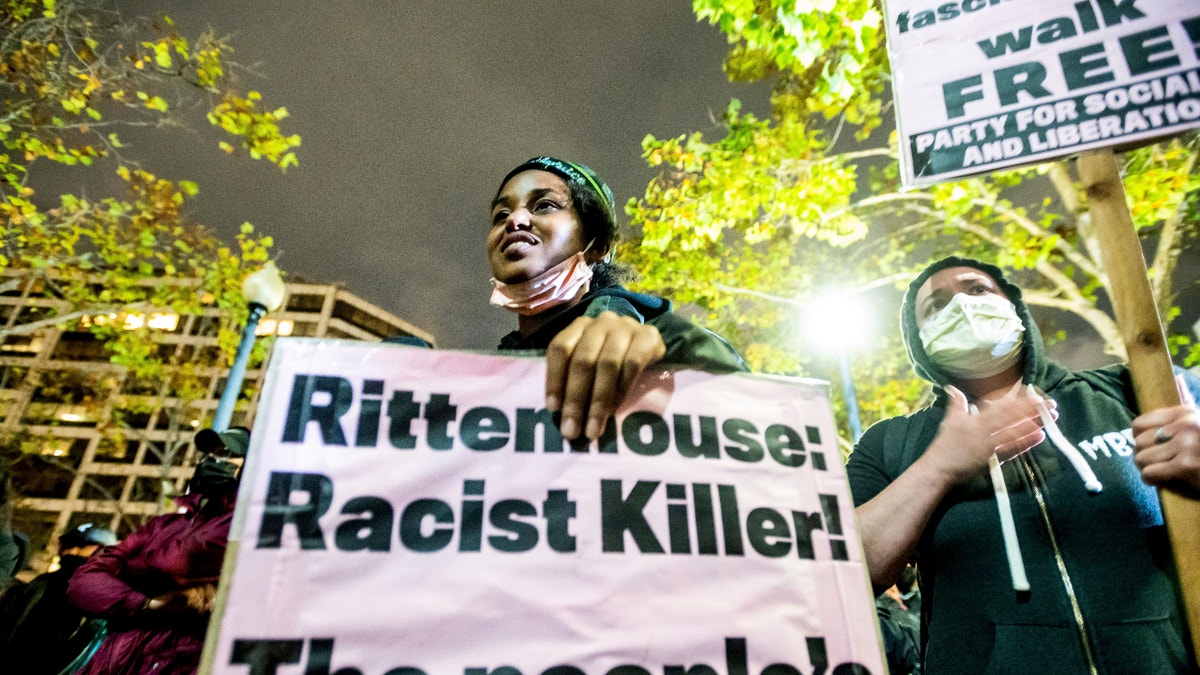 Bria Swenson holds a sign Friday, Nov. 19, 2021, in Oakland, Calif., following the acquittal of Kyle Rittenhouse in Kenosha, Wis. Asserting self-defense, Rittenhouse was acquitted of all charges Friday in the deadly shootings that became a flashpoint in the debate over guns, vigilantism and racial injustice in the United States. (AP Photo/Noah Berger)