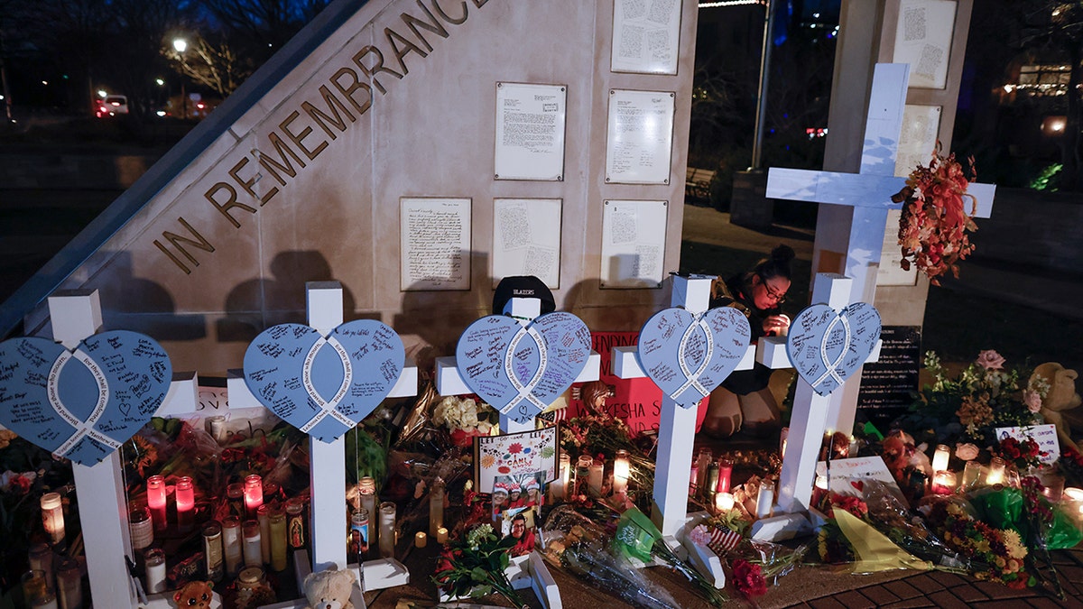 Amy Mack lights candles at a memorial at Veteran's Park for the victims of Sunday's deadly Christmas parade crash in Waukesha, Wisconsin, Tuesday, Nov. 23, 2021.