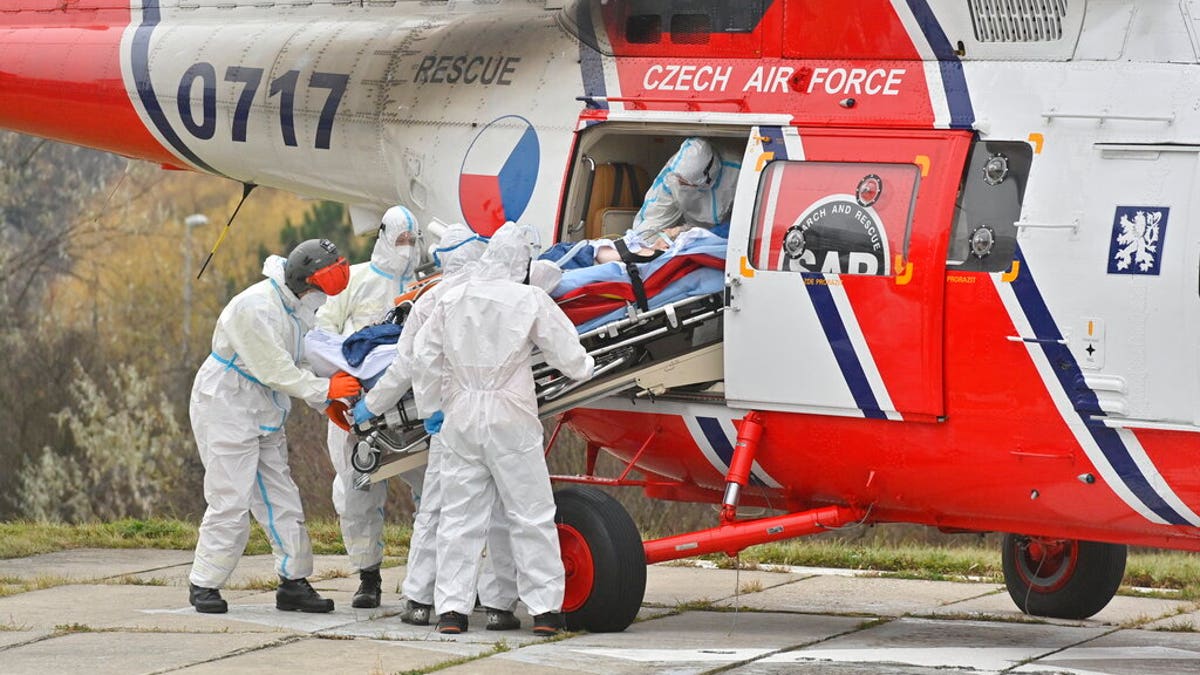 Health workers at the Motol University Hospital take out of army helicopter one of the patients with COVID-19, who was transported to Prague from a hospital in Brno, Czech Republic, Thursday, Nov. 25, 2021. (Vit Simanek / CTK via AP)