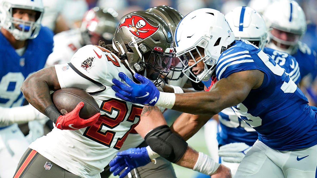 Tampa Bay Buccaneers' Ronald Jones (27) runs against Indianapolis Colts' Bobby Okereke (58) during the first half of an NFL football game, Sunday, Nov. 28, 2021, in Indianapolis.