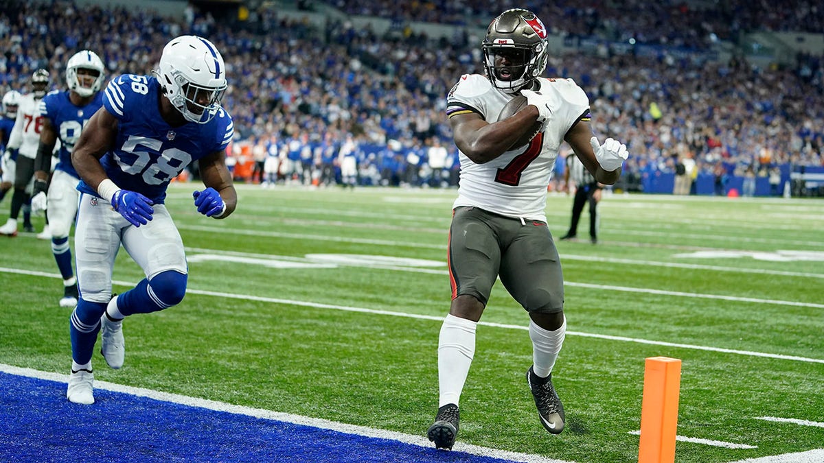 Tampa Bay Buccaneers' Leonard Fournette (7) goes in for a touchdown against Indianapolis Colts' Bobby Okereke (58) during the first half of an NFL football game, Sunday, Nov. 28, 2021, in Indianapolis.