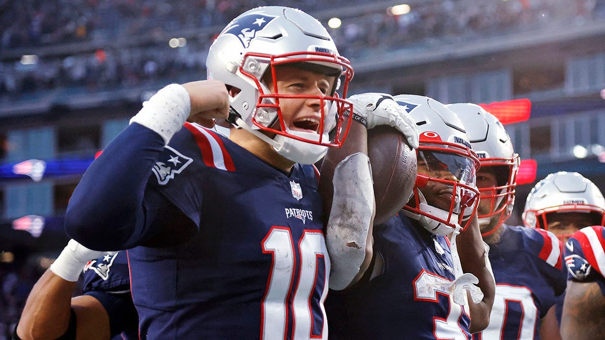 New England Patriots running back Damien Harris, right, celebrates with quarterback Mac Jones, left, after his touchdown during the second half of an NFL football game against the Tennessee Titans, Sunday, Nov. 28, 2021, in Foxborough, Massachusetts.