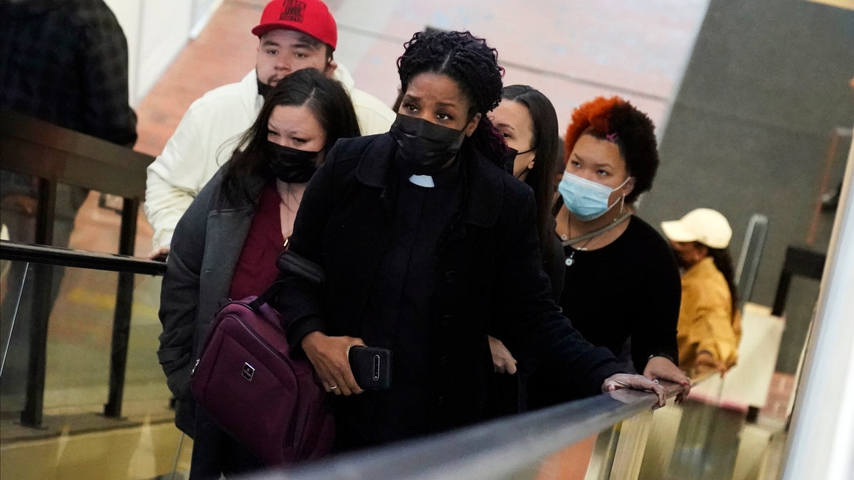 The family of Daunte Wright, led by his mother Katie, second from left, a clergy member, front center, and son Damik, at left with red cap, arrive Tuesday, Nov. 30, 2021, at the Government Center in Minneapolis. (AP Photo/Jim Mone)