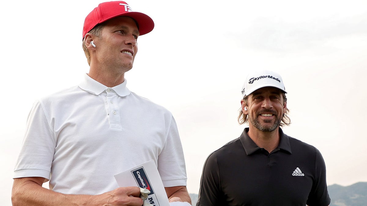 Tom Brady, left, and Aaron Rodgers walk across the golf course during Capital One's The Match at The Reserve at Moonlight Basin in Big Sky, Montana, on July 6, 2021.