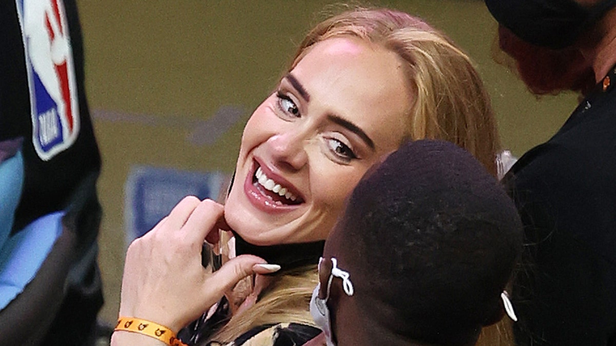 Singer Adele smiles with sports agent Rich Paul, who she began publicly dating in September. 