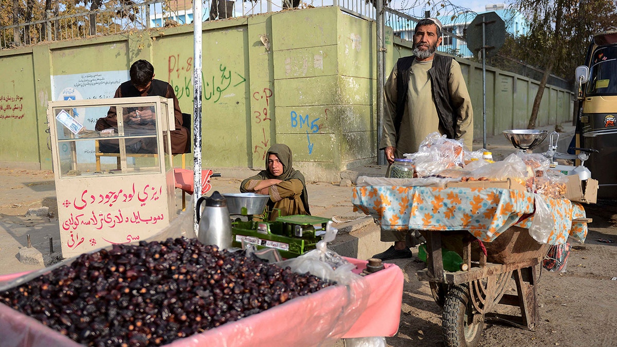 A vendor sells dates along a road in Kandahar on November 29, 2021. (Photo by JAVED TANVEER/AFP via Getty Images)