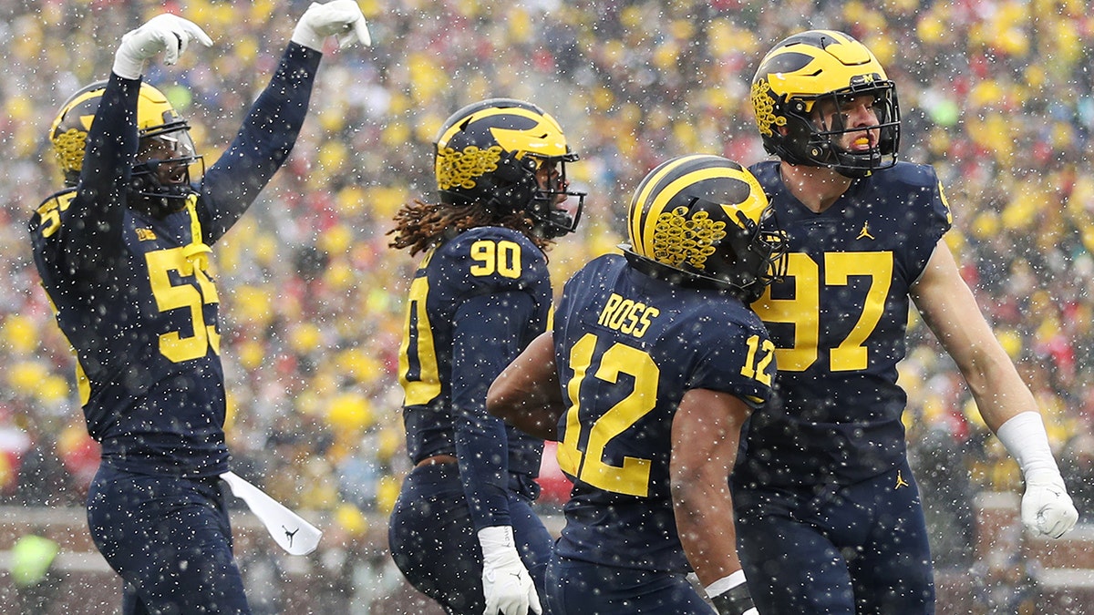 Aidan Hutchinson (97) of the Michigan Wolverines celebrates a sack against the Ohio State Buckeyes with teammates during the first quarter at Michigan Stadium on Nov. 27, 2021, in Ann Arbor, Michigan.