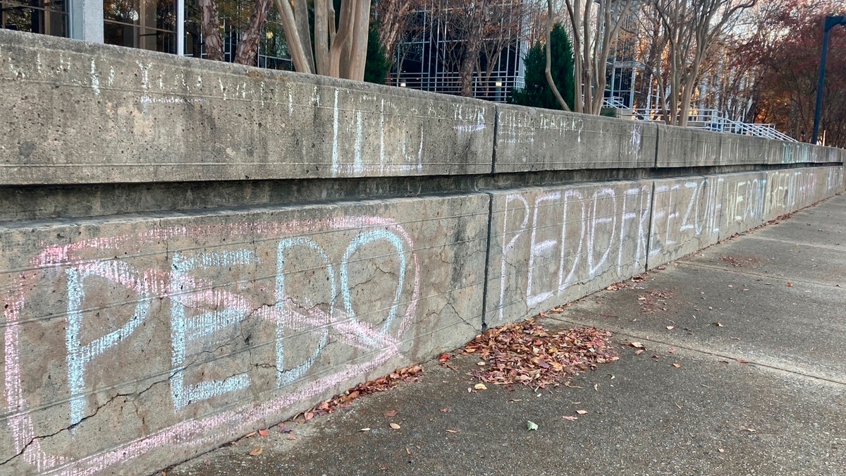Anti-pedophilia graffiti is scrawled in chalk on the campus of Old Dominion University in Norfolk, Va.,, on Wednesday Nov. 24, 2021. (AP Photo/Ben Finley)
