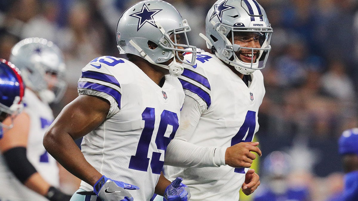 ARLINGTON, TEXAS - OCTOBER 10: Dak Prescott #4 of the Dallas Cowboys celebrates with Amari Cooper #19 after a touchdown during the fourth quarter against the New York Giants at AT&T Stadium on October 10, 2021 in Arlington, Texas.