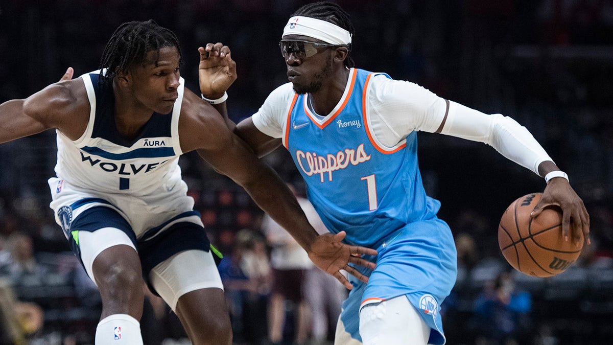 Los Angeles Clippers guard Reggie Jackson, right, drives toward the basket as Minnesota Timberwolves forward Anthony Edwards defends during the second half of an NBA basketball game in Los Angeles on Saturday, Nov. 13, 2021.