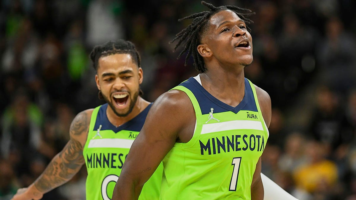 Minnesota Timberwolves guard Anthony Edwards (1) and guard D'Angelo Russell react after Edwards made a three point shot during the first half of an NBA basketball game Saturday, Nov. 20, 2021, in Minneapolis.