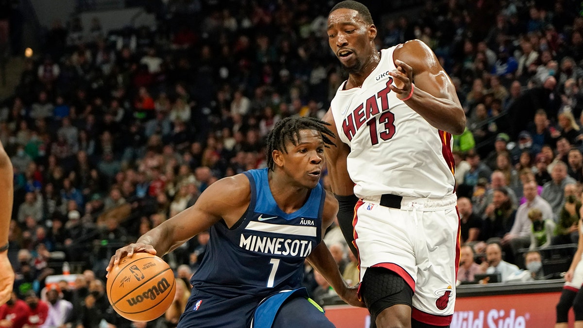 Minnesota Timberwolves guard Anthony Edwards (1) drives past Miami Heat center Bam Adebayo during the first half of an NBA basketball game Wednesday, Nov. 24, 2021, in Minneapolis.