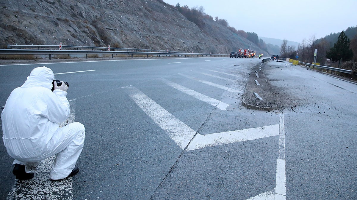 A member of forensic police works near the site where a bus with North Macedonian plates caught fire on a highway, near the village of Bosnek, Bulgaria, November 23, 2021. REUTERS/Stoyan Nenov