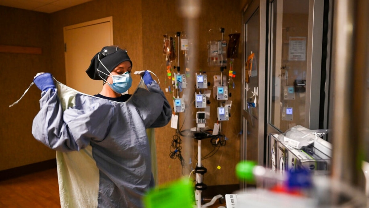 North Memorial Health Hospital Critical Care Nurse Kayla Lynch donned a protective gown before entering the room of a COVID-19 patient during her shift Dec. 7, 2020. 