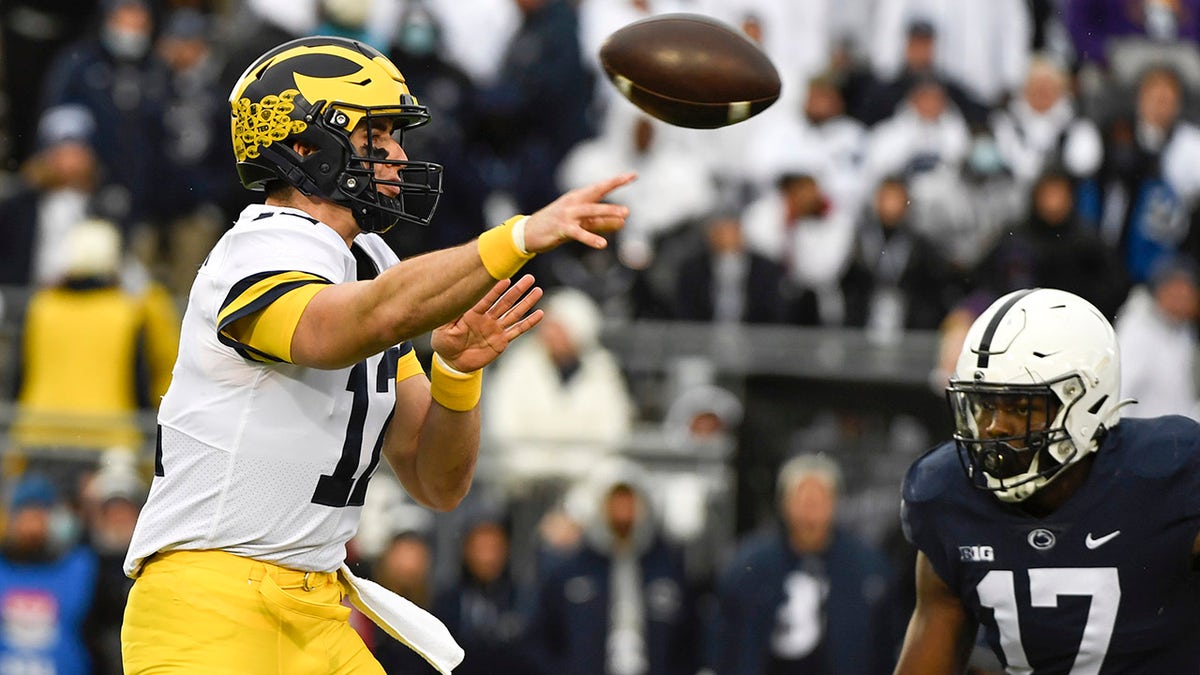 Michigan quarterback Cade McNamara (12) passes while being pressured by Penn State defensive end Arnold Ebiketie (17) in the first quarter of an NCAA college football game in State College, Pa., Saturday, Nov. 13, 2021.