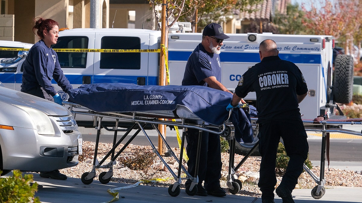 Los Angeles County Coroner officials remove a body from a home where five bodies were found dead, in the city of Lancaster