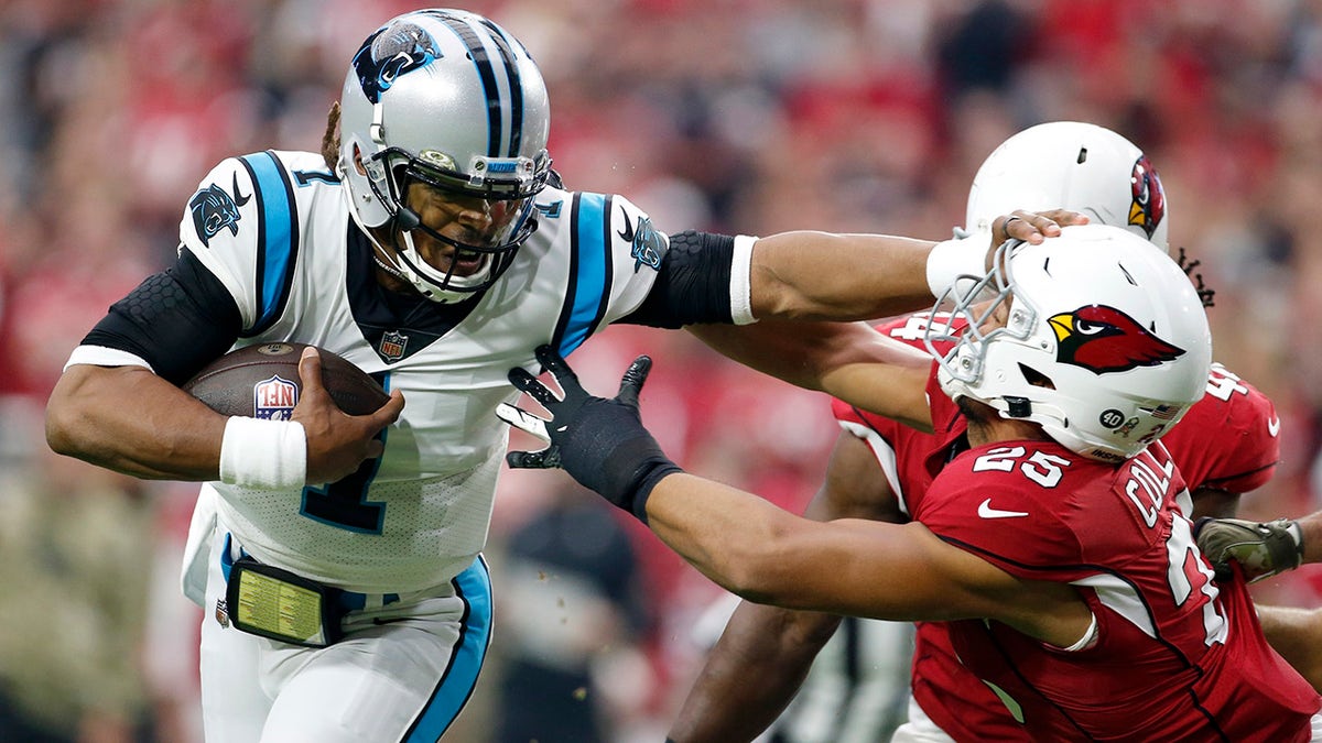 Carolina Panthers quarterback Cam Newton (1) gives Arizona Cardinals inside linebacker Zaven Collins (25) a shove as Newton runs for a touchdown during the first half of an NFL football game Sunday, Nov. 14, 2021, in Glendale, Ariz.