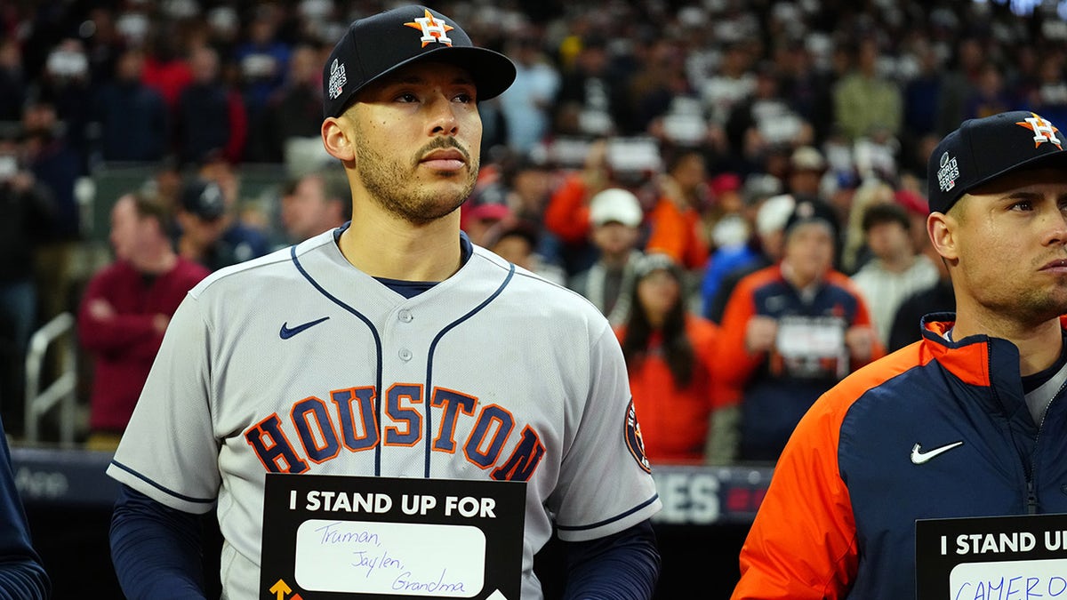 ATLANTA, GA - OCTOBER 30: Carlos Correa #1 of the Houston Astros holds up a Stand Up To Cancer placard at the end of the fifth inning of Game 4 of the 2021 World Series between the Houston Astros and the Atlanta Braves at Truist Park on Saturday, October 30, 2021 in Atlanta, Georgia.
