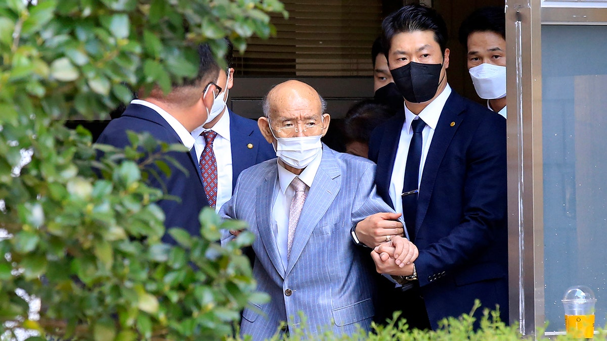 Former South Korean President Chun Doo-hwan, center, comes out of his house to attend his trial on the charge of libel in Seoul, South Korea, on Aug. 9, 2021. 