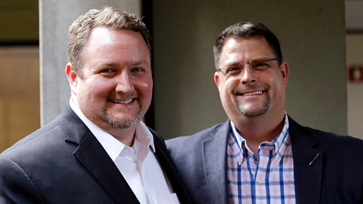 Curt Freed, left, and his partner Robert Ingersoll pose for a photo after a hearing before Washington's Supreme Court, Tuesday, Nov. 15, 2016, in Bellevue, Wash. The couple sued florist Barronelle Stutzman for refusing to provide services for their wedding and Stutzman she was exercising her First Amendment rights, but justices questioned whether ruling in her favor would mean other businesses could turn away customers based on racial or other grounds. (AP Photo/Elaine Thompson)