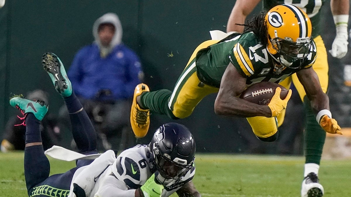 The Seattle Seahawks' Quandre Diggs stops the Green Bay Packers' Davante Adams after a catch during the first half of an NFL football game Sunday, Nov. 14, 2021, in Green Bay, Wisconsin.