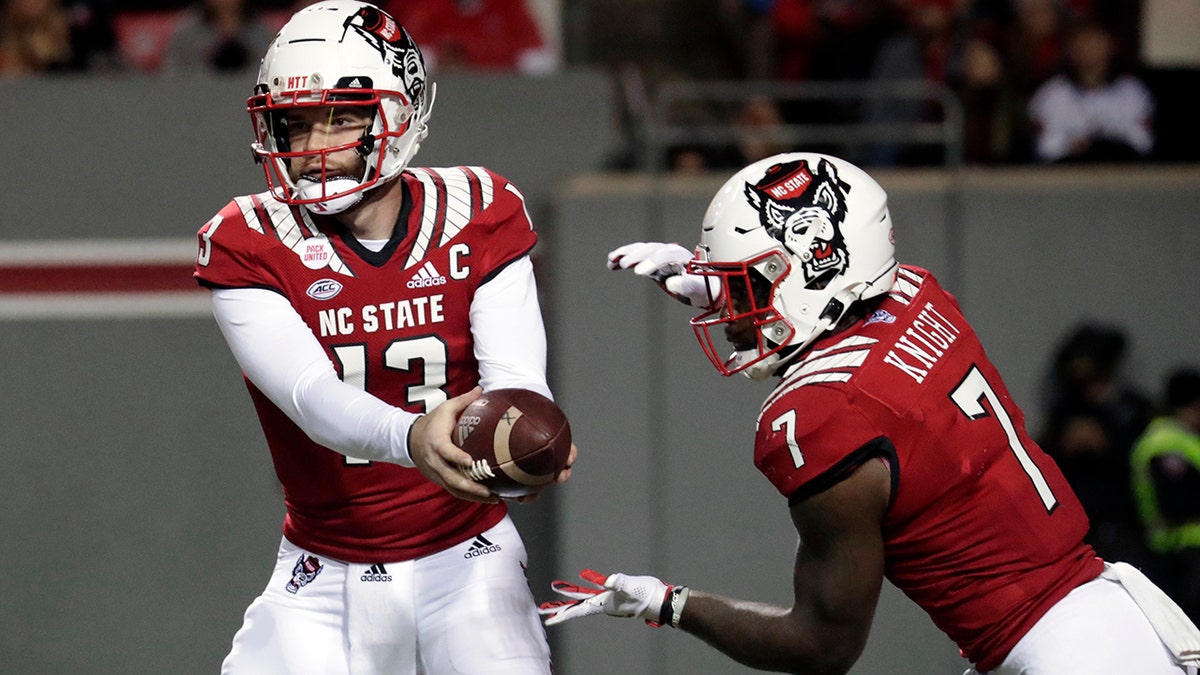North Carolina State quarterback Devin Leary (13) hands off to running back Zonovan Knight (7) during the first half of the team's NCAA college football game against North Carolina on Friday, Nov. 26, 2021, in Raleigh, North Carolina.