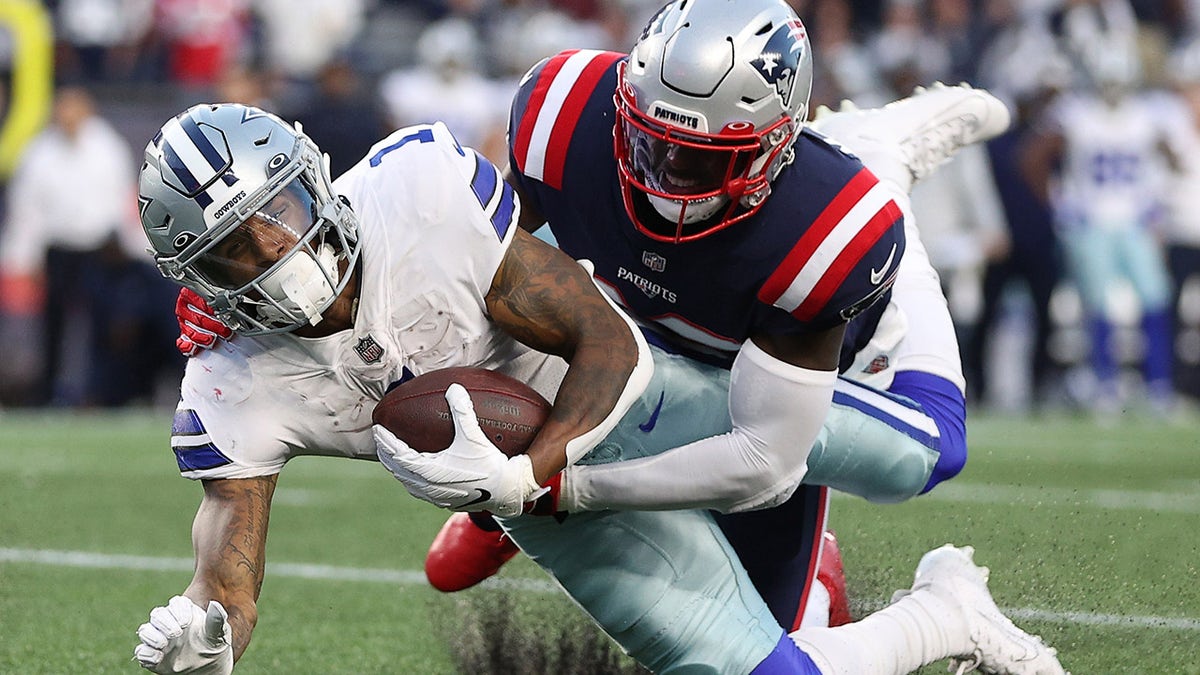 Ced Wilson of the Dallas Cowboys is tackled by Devin McCourty of the New England Patriots in the second quarter at Gillette Stadium on Oct. 17, 2021, in Foxborough, Massachusetts.