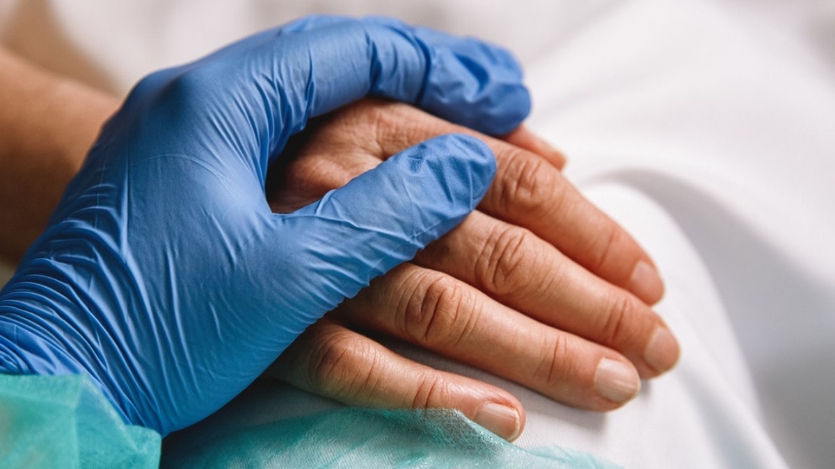 A photo of a doctor and patient's hand