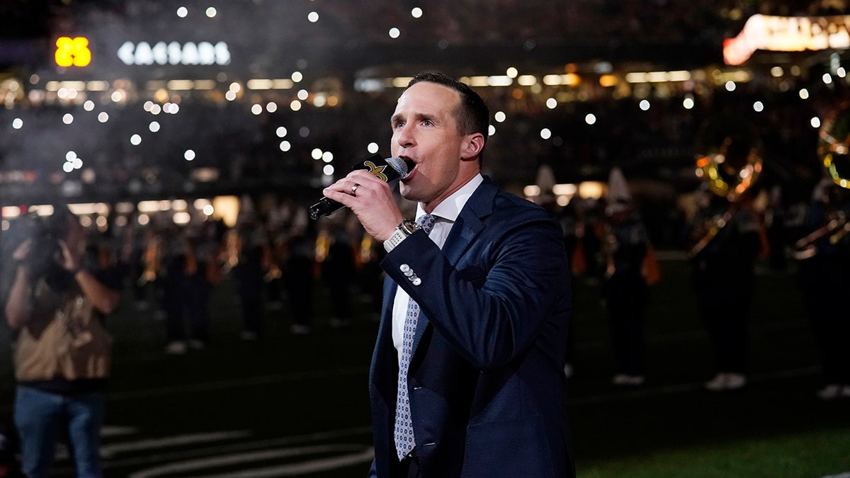 Former New Orleans Saints quarterback Drew Brees leads a crowd cheer as he is honored during a ceremony at halftime of an NFL football game between the New Orleans Saints and the Buffalo Bills in New Orleans, Thursday, Nov. 25, 2021.