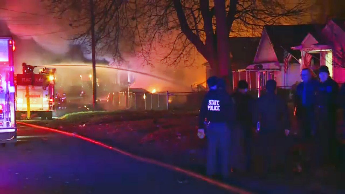 Michigan State Police and others are seen near the site of a fire and possible explosions in Flint, Michigan, Nov. 22, 2021. (FOX 66)