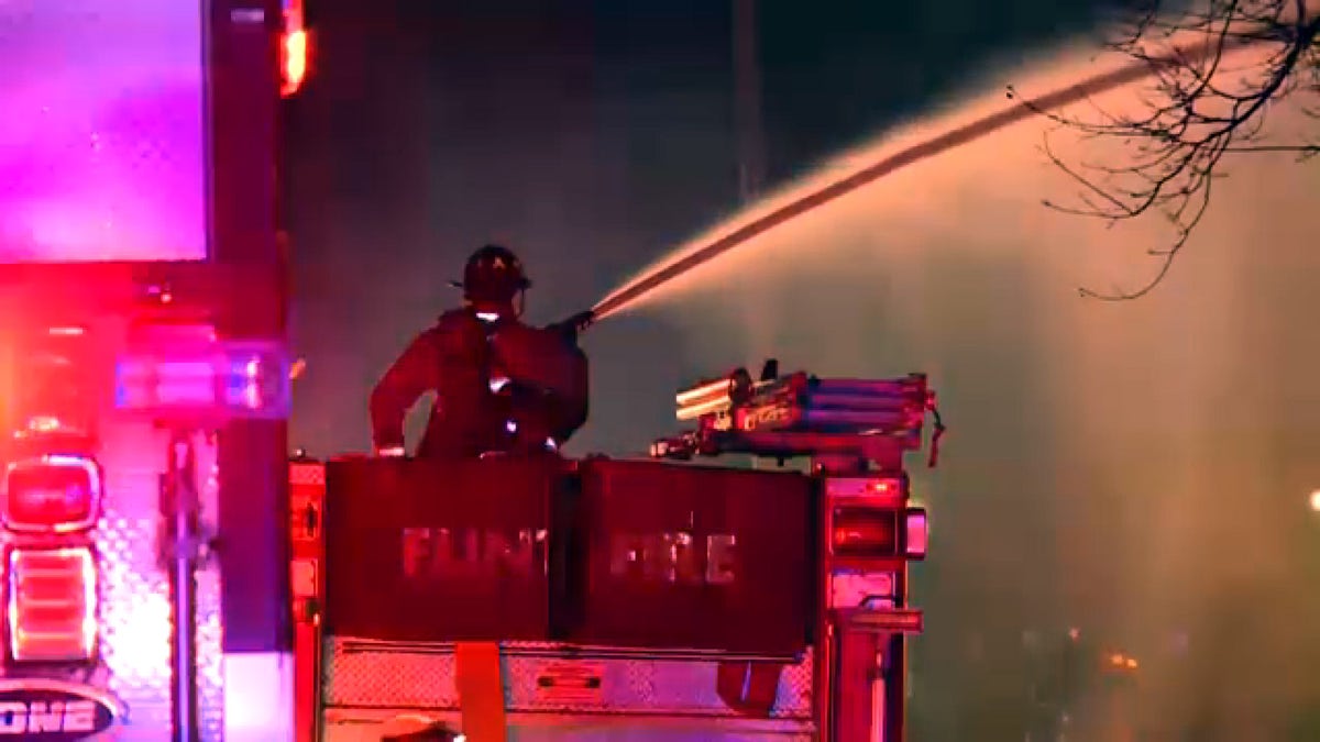 A Flint firefighter direct a hose toward a blaze, Nov. 22, 2021. (FOX 66)