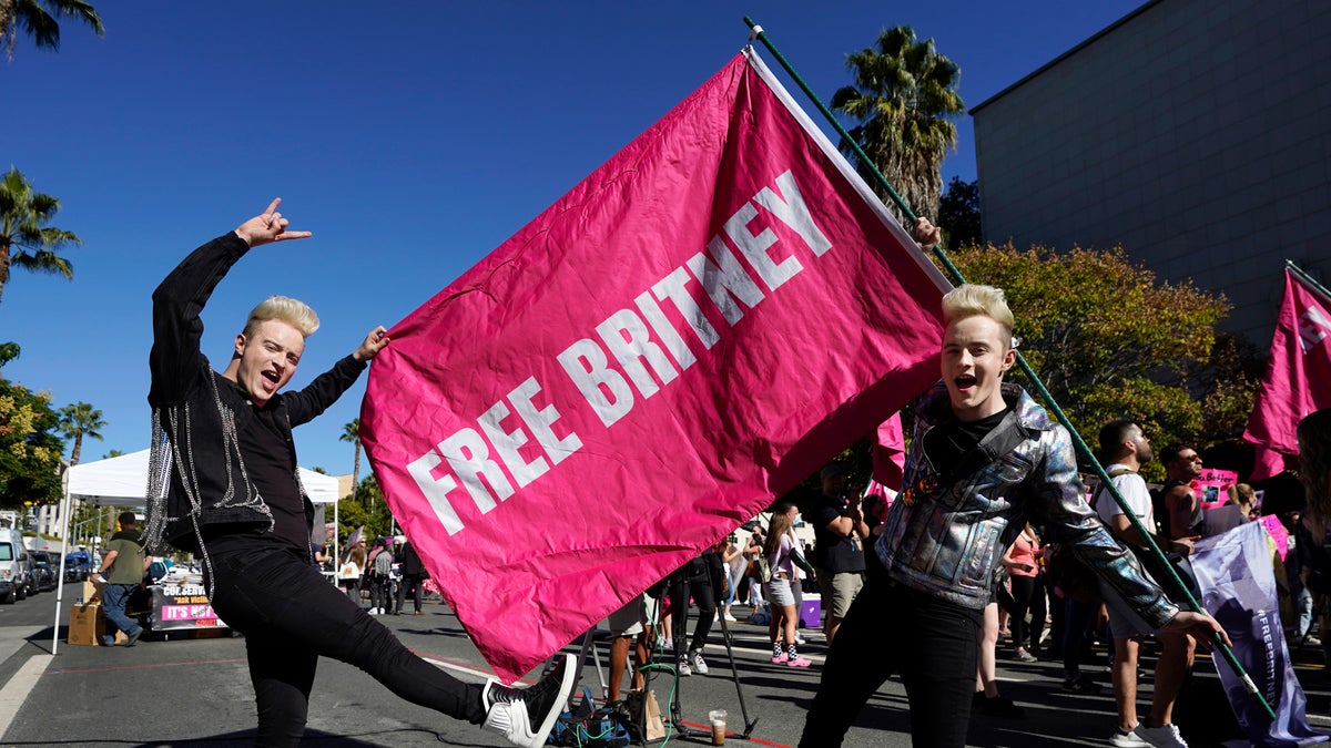 Twins Edward, right, and John Grimes of Dublin, Ireland, hold a ‘Free Britney’ flag outside a hearing concerning the pop singer's conservatorship at the Stanley Mosk Courthouse, Friday, Nov. 12, 2021, in Los Angeles.