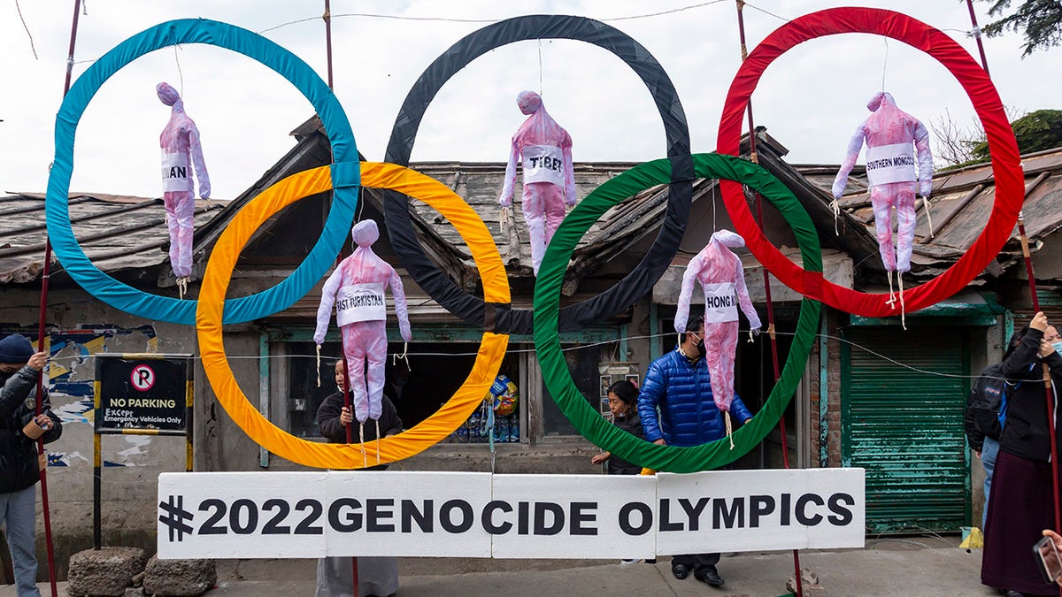 In this Feb. 3, 2021, file photo, exile Tibetans use the Olympic Rings as a prop as they hold a street protest against the holding of 2022 Winter Olympics in Beijing in Dharmsala, India.