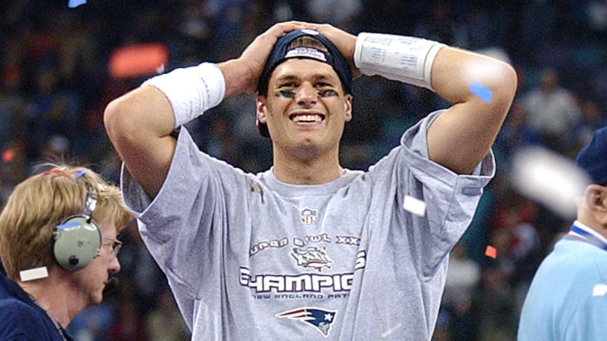 New England Patriots quarterback and Super Bowl MVP Tom Brady reacts on the podium following New England's upset victory over the St. Louis Rams in the 2002 Super Bowl in the Louisiana Superdome in New Orleans Feb. 3, 2002.