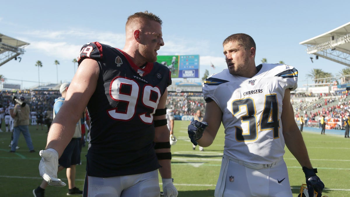 J.J. Watt #99 of the Houston Texans and brother Derek Watt #34 of the Los Angeles Chargers walk off the field following the Texans 27-20 victory over the Chargers at Dignity Health Sports Park on Sept. 22, 2019 in Carson, California.
