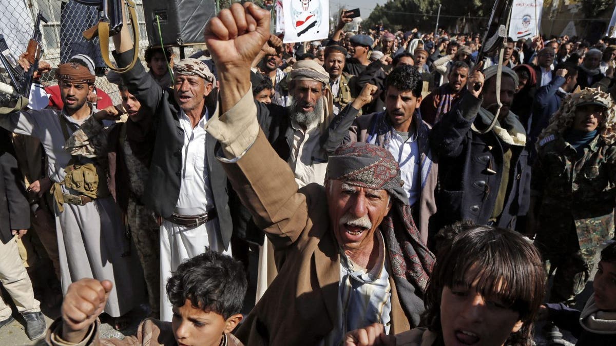 Supporters of Yemen's Houthi movement raise their fists as they chant slogans during a demonstration in front of the closed U.S. Embassy in the capital of Sana’a Jan. 18, 2021, to reject outgoing US President Donald Trump's decision to designate the Houthi group a "foreign terrorist organization."