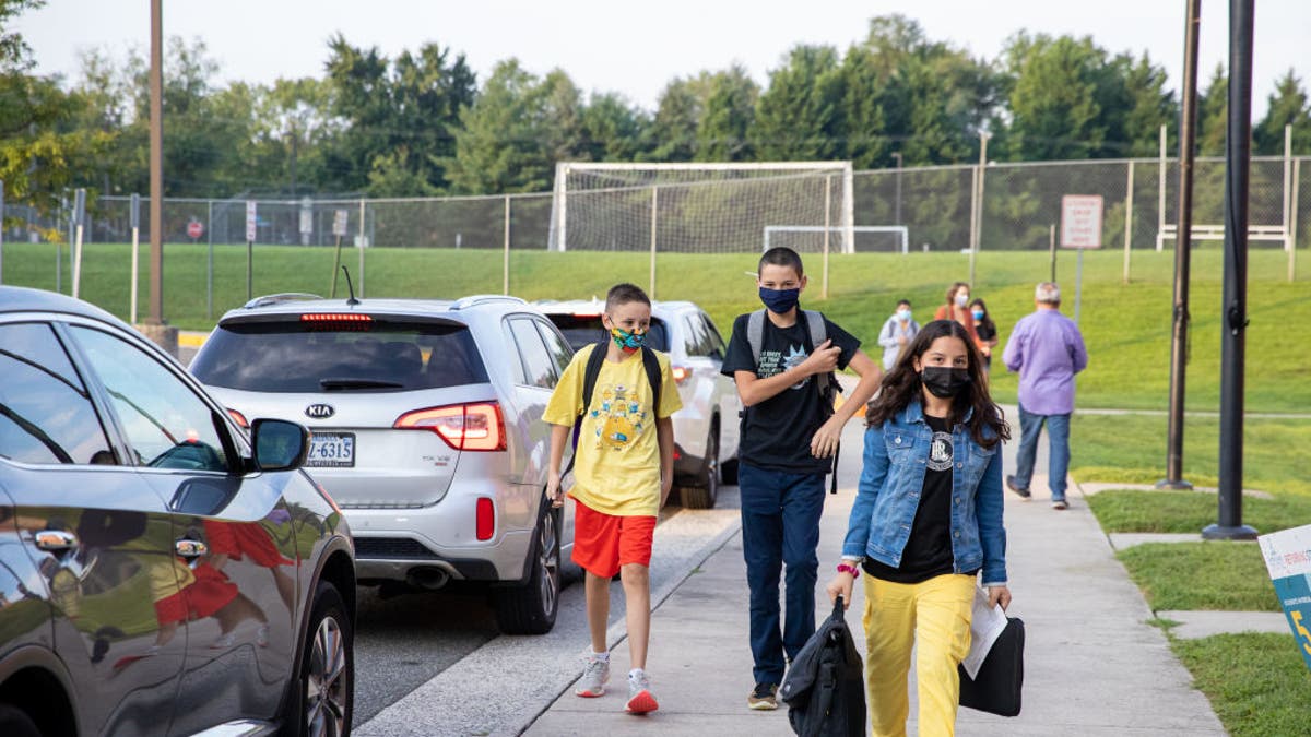 Masked students arrive to school