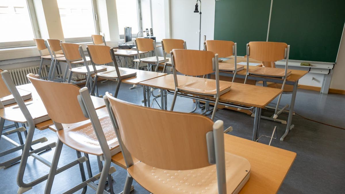 An empty classroom with the chairs up.
