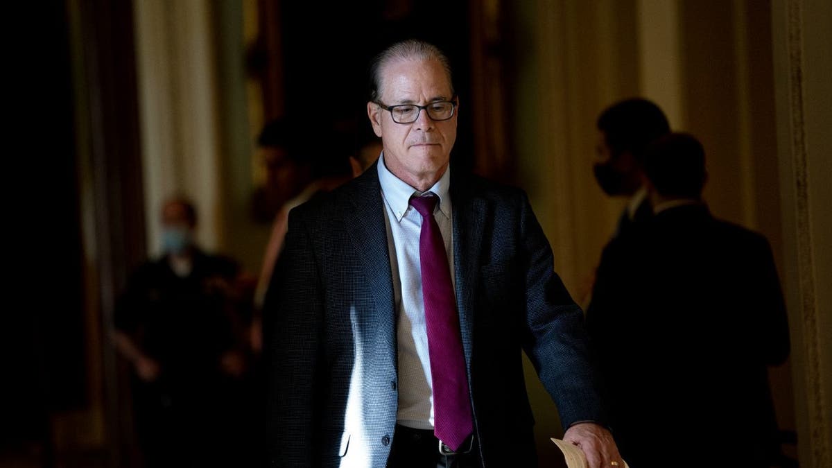 Sen Braun wears suit and tie as he walks through Capitol Building